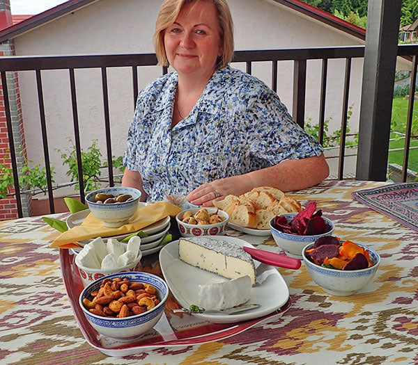 A woman with cheese and bread at a table