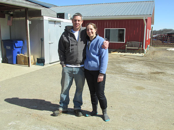 two people standing together on farm