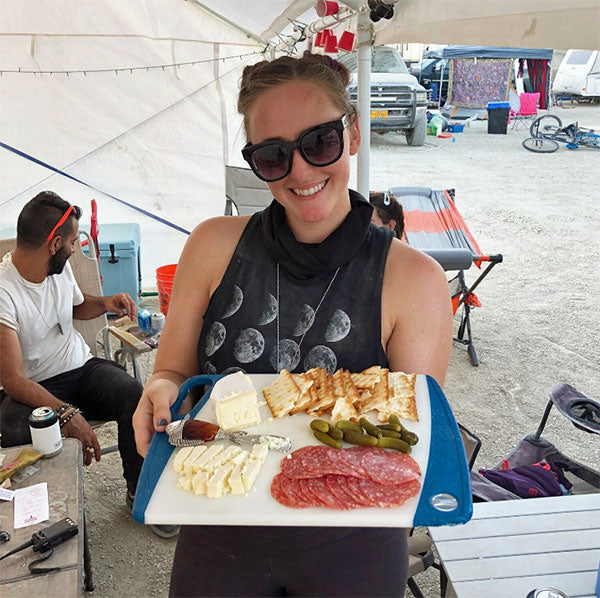 woman holding platter of metas and cheese