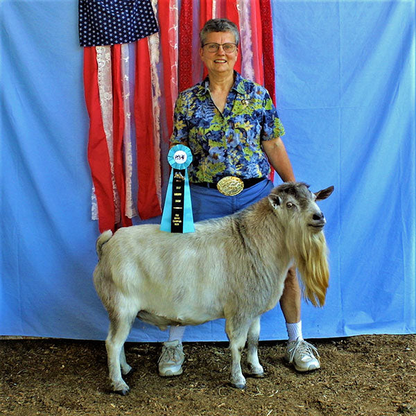 Woman with bearded goat and ribbon in front of American flag