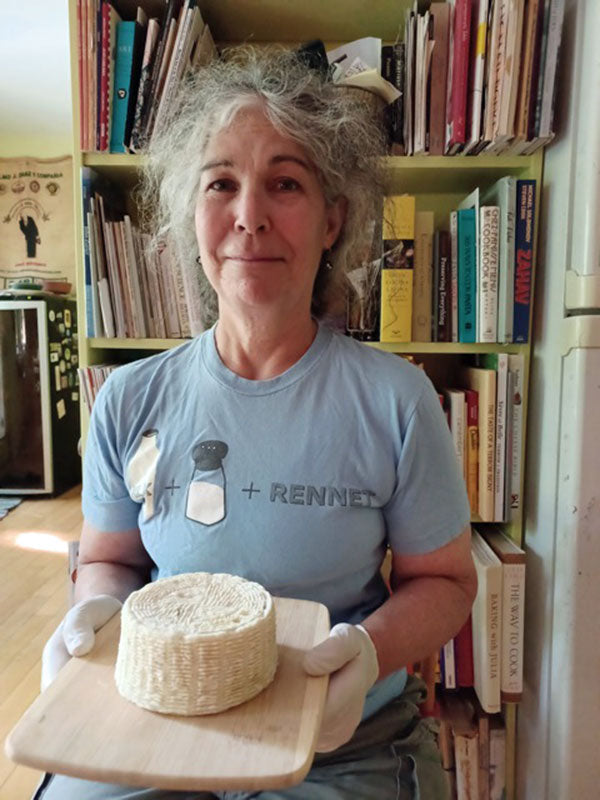 Woman holding a tray with block of goat milk tomme