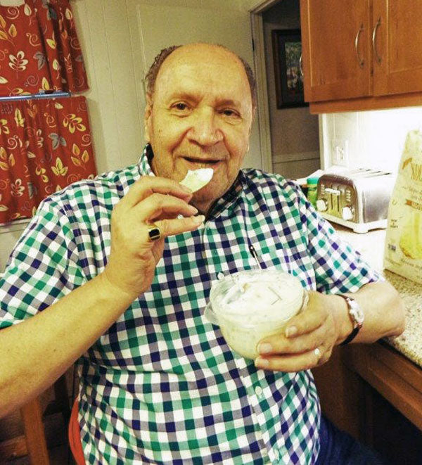 Man eating chip with dip while holding dip container