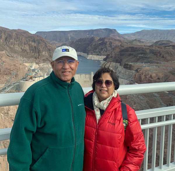 A couple smiling in front of moutains