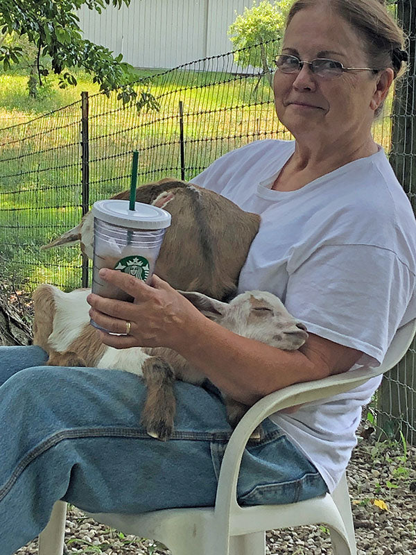 A woman holding goats