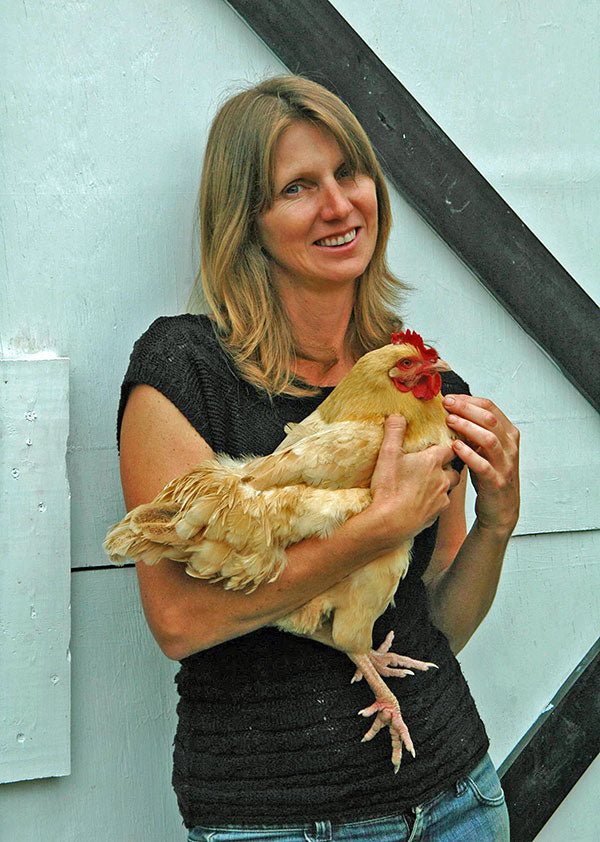 A woman holding a chicken.