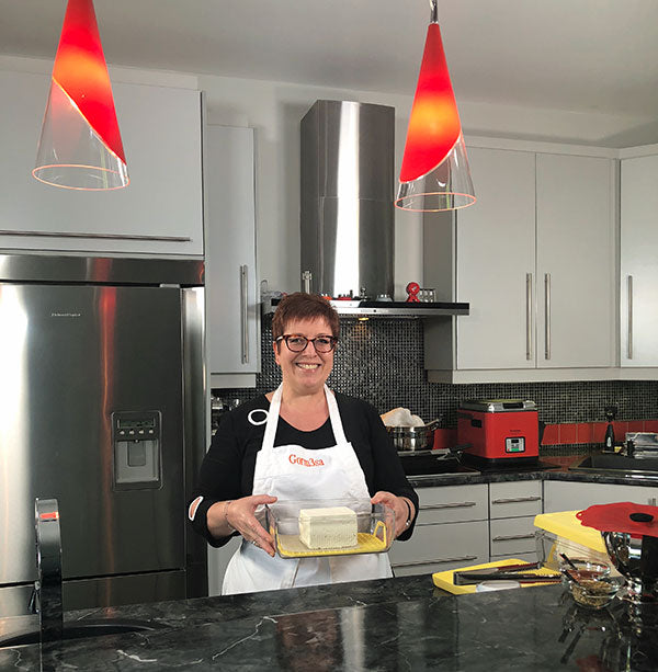 Woman holding container with block of cheese