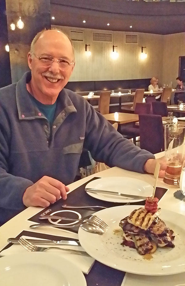 Man with plate of chicken in a restaurant