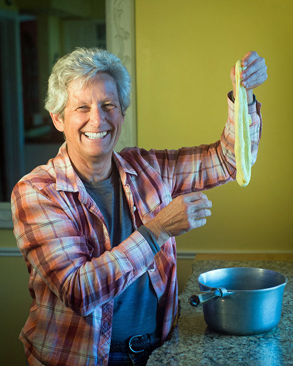 Someone holding food over a pot