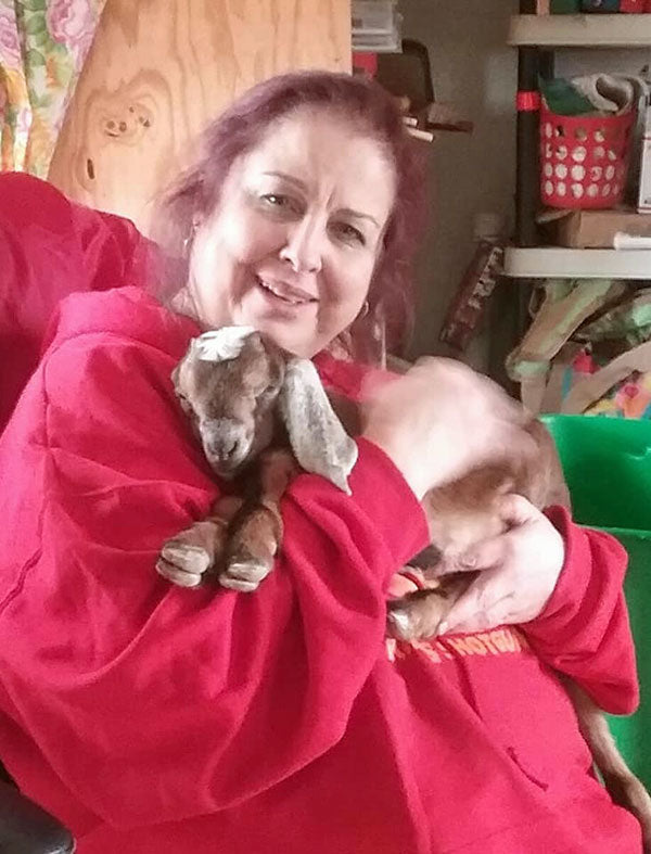 Woman holding baby goat